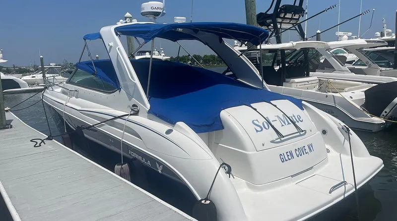Slide: The Image of 2003 Formula 370 SS boat docked, featuring blue canopy and cover, Glen Cove, NY. - 2
