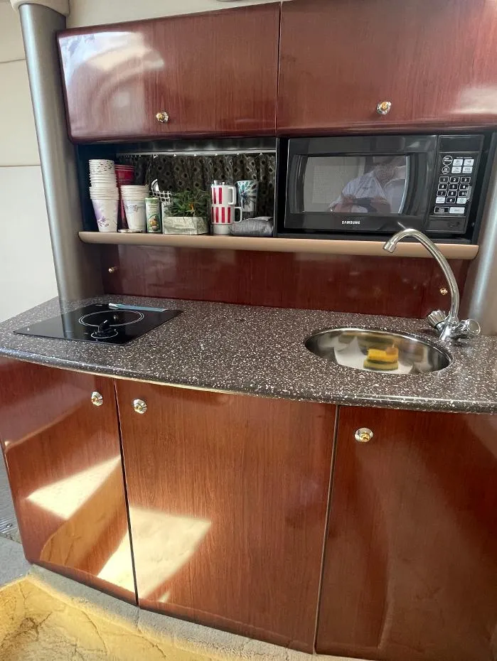 Slide: The Image of 2003 Formula 370 SS yacht kitchenette with microwave, sink, and stove. - 9