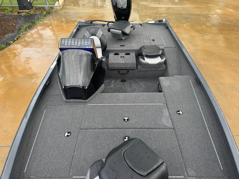 Slide: The Image of 2025 Crestliner XF 179 boat on trailer at dealership, surrounded by trees and other boats. - 3