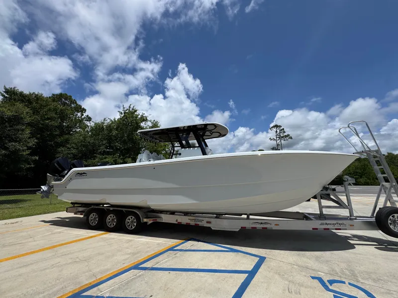 Slide: The Image of 2026 Invincible 36 Catamaran on trailer under blue sky with clouds. - 10