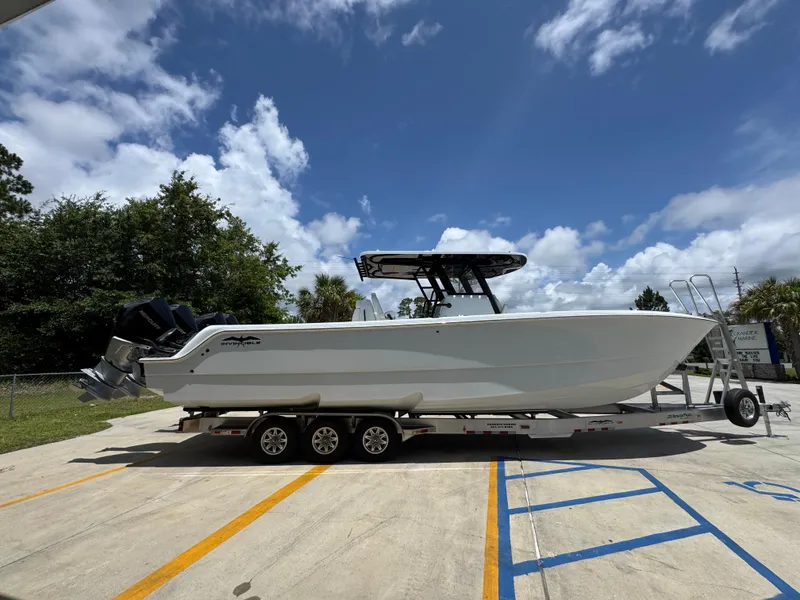 Slide: The Image of 2026 Invincible 36 Catamaran on trailer under blue sky, side view. - 11