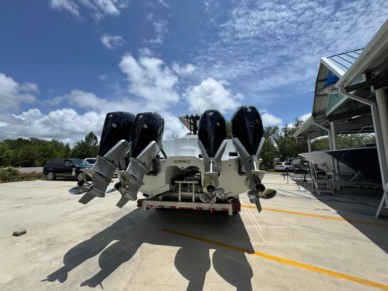 Slide: The Image of 2026 Invincible 36 Catamaran with four powerful outboard motors, parked under a partly cloudy sky. - 14
