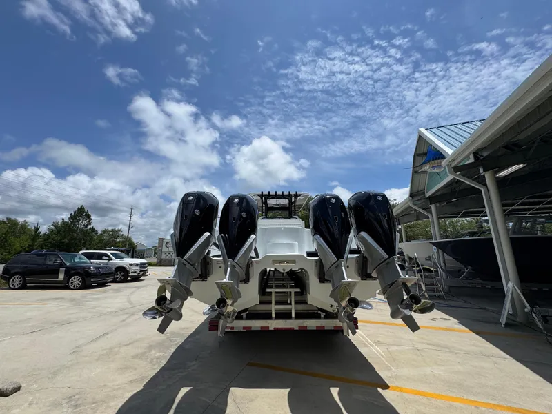 Slide: The Image of 2026 Invincible 36 Catamaran with four powerful outboard engines, parked outdoors under a blue sky. - 15