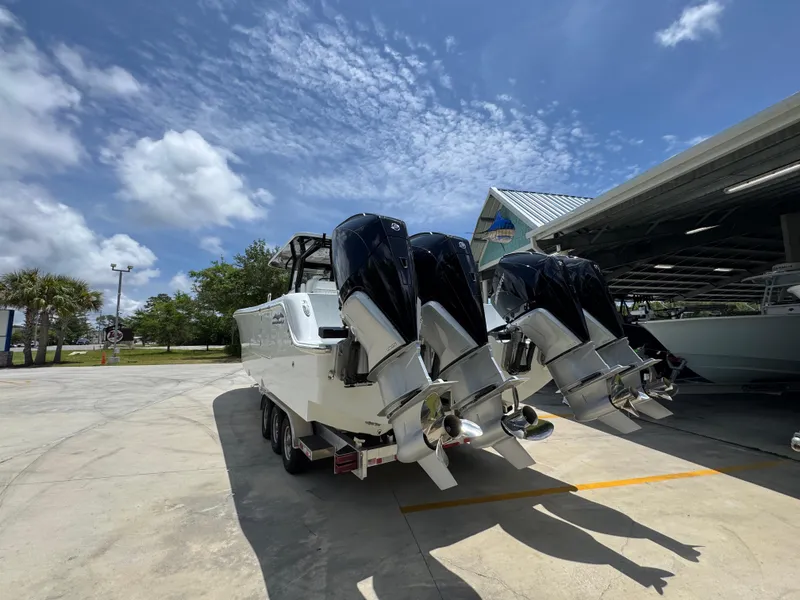 Slide: The Image of 2026 Invincible 36 Catamaran with powerful outboard engines, parked outdoors under a clear sky. - 16