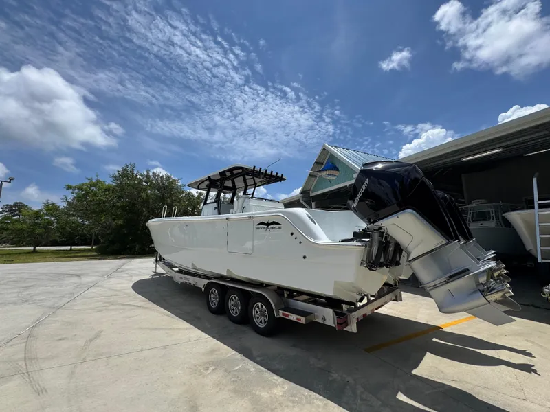 Slide: The Image of 2026 Invincible 36 Catamaran on trailer, parked outdoors under a clear blue sky. - 17