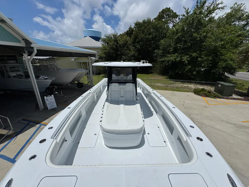 Slide: The Image of 2026 Invincible 36 Catamaran with sleek design, docked outdoors under a partly cloudy sky. - 20