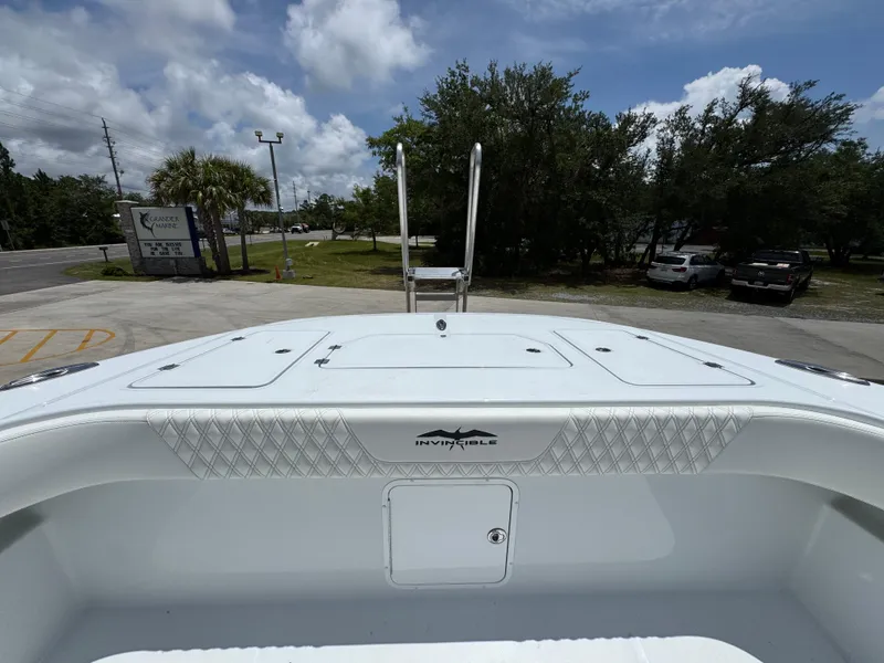 Slide: The Image of 2026 Invincible 36 Catamaran boat deck with storage compartments, parked outdoors under a cloudy sky. - 24