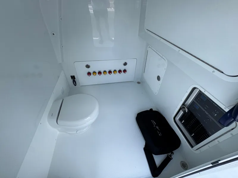Slide: The Image of Interior of 2026 Invincible 36 Catamaran featuring a compact marine toilet and control panel. - 29