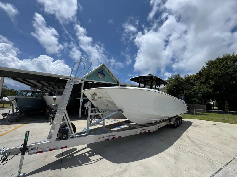 Slide: The Image of 2026 Invincible 36 Catamaran on trailer under blue sky with clouds. - 4