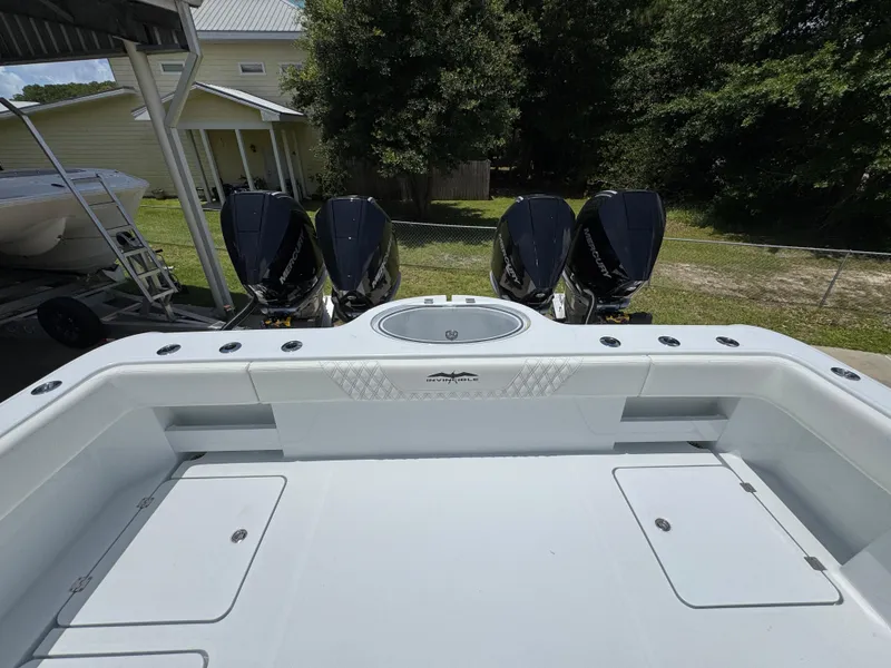 Slide: The Image of 2026 Invincible 36 Catamaran with triple outboard engines, docked outdoors. - 41