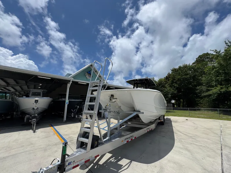 Slide: The Image of 2026 Invincible 36 Catamaran on trailer under blue sky, parked near other boats. - 5