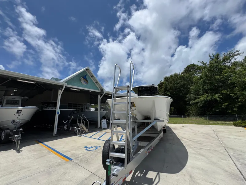 Slide: The Image of 2026 Invincible 36 Catamaran on trailer under blue sky, parked near a building. - 6