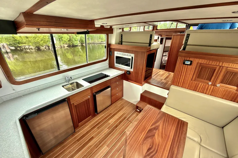 Slide: The Image of Interior of 2023 Nordic Tug 34, featuring modern kitchen and seating area with wood finishes. - 14