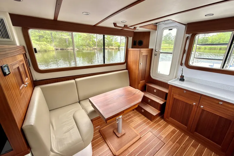 Slide: The Image of Interior of 2023 Nordic Tug 34, featuring wood finish, seating, and large windows. - 16