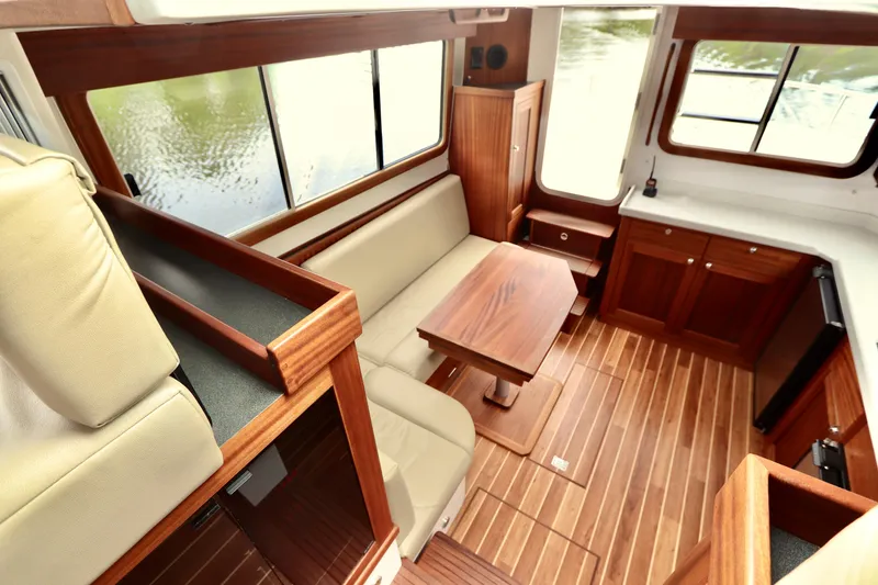 Slide: The Image of Interior of 2023 Nordic Tug 34, featuring wood finishes and comfortable seating. - 18