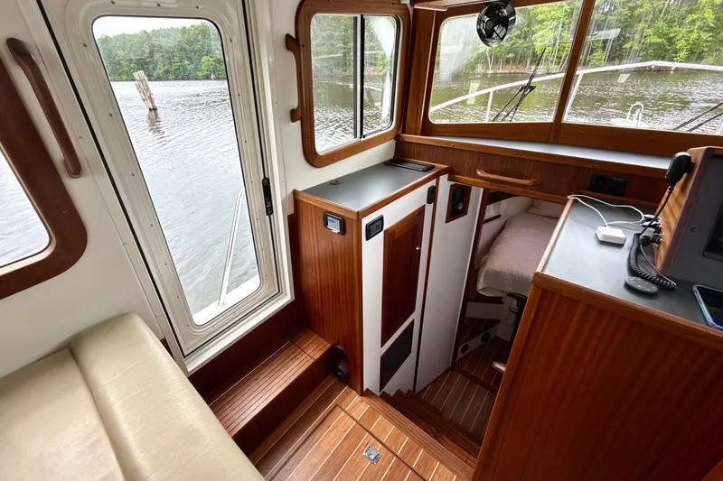 Slide: The Image of Interior of 2023 Nordic Tug 34, featuring wood paneling and water view. - 19