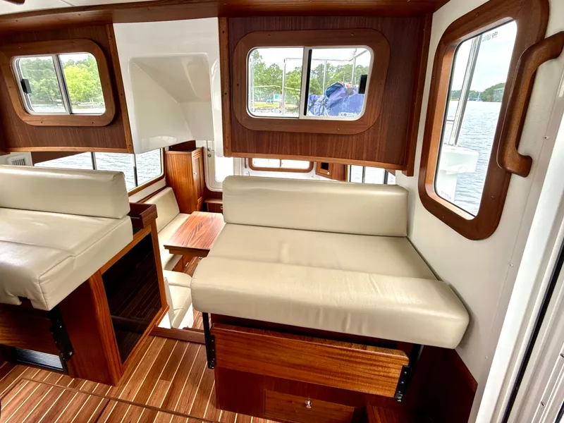 Slide: The Image of Interior of 2023 Nordic Tug 34, featuring wood accents and cream seating. - 20
