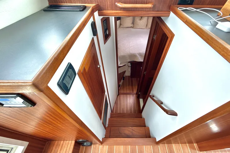 Slide: The Image of Interior view of 2023 Nordic Tug 34, featuring wooden stairs and cozy cabin. - 23