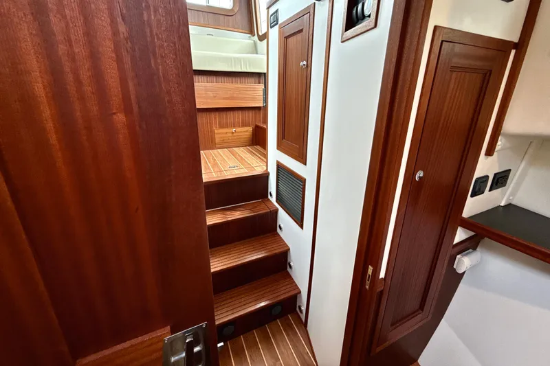 Slide: The Image of Interior of 2023 Nordic Tug 34, featuring wooden stairs and cabinetry. - 24
