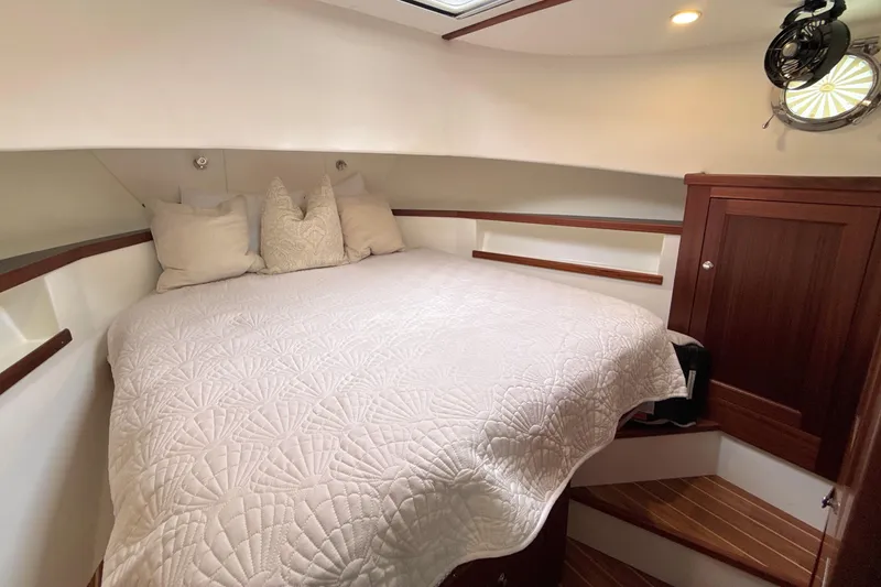 Slide: The Image of Cozy cabin interior of 2023 Nordic Tug 34 with bed and wooden cabinetry. - 26