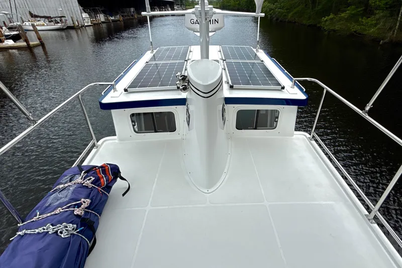 Slide: The Image of 2023 Nordic Tug 34 Tug with solar panels on deck, docked by a river. - 7