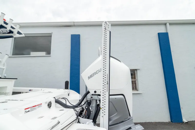 Slide: The Image of 2026 Crevalle 24 HCO boat with Mercury engine, docked near a blue and white building. - 10