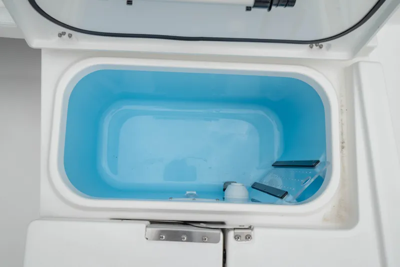 Slide: The Image of Open storage compartment on 2026 Crevalle 24 HCO boat, featuring a blue interior. - 16