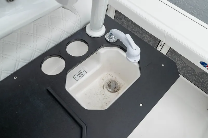 Slide: The Image of 2026 Crevalle 24 HCO boat sink with faucet and cup holders. - 18
