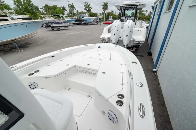 Slide: The Image of 2026 Crevalle 24 HCO boat with dual engines, docked outdoors. - 2