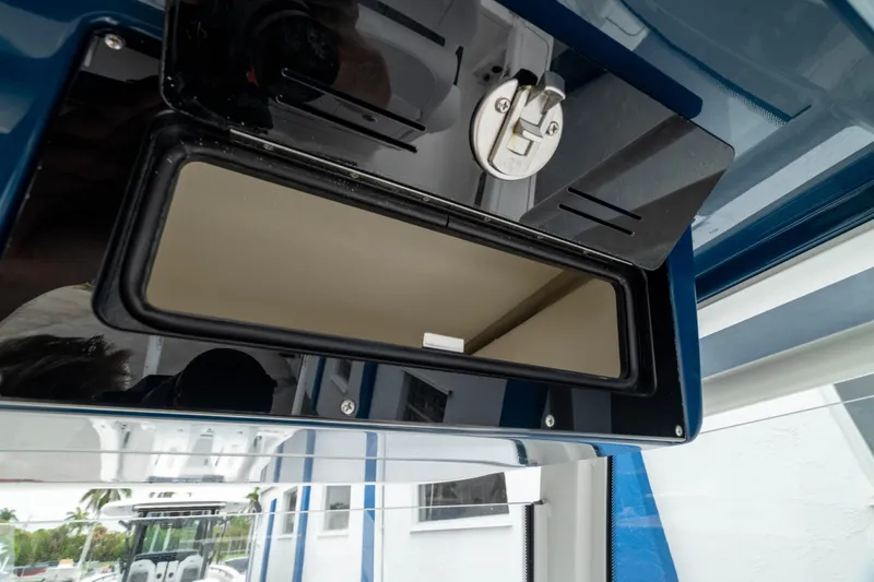 Slide: The Image of 2026 Crevalle 24 HCO boat storage compartment with secure latch, open view. - 22