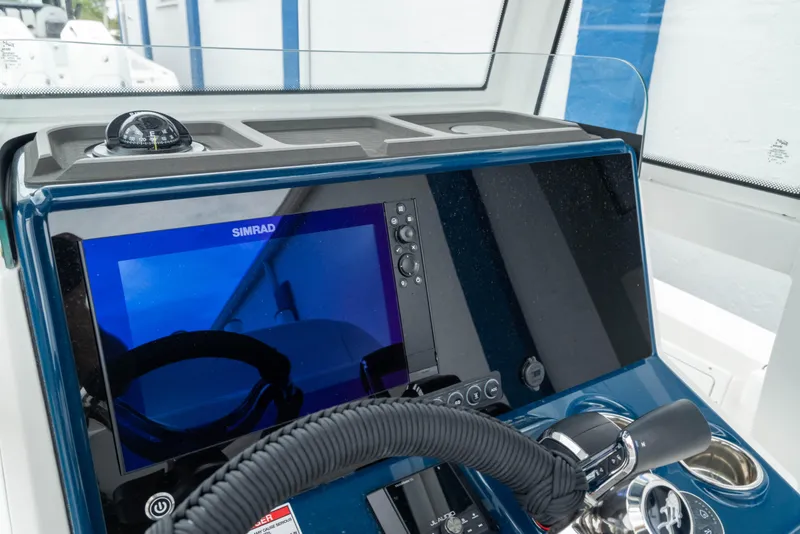 Slide: The Image of Helm of 2026 Crevalle 24 HCO boat with Simrad display and steering wheel. - 23