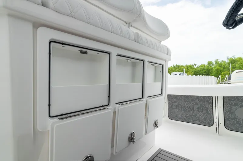 Slide: The Image of 2026 Crevalle 24 HCO boat storage compartments with cushioned seating, white interior. - 31