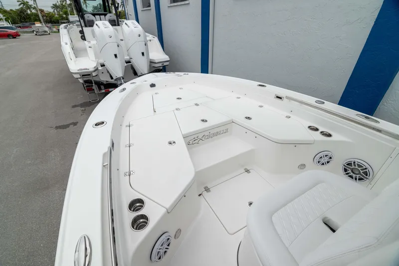 Slide: The Image of 2026 Crevalle 24 HCO boat with spacious deck and seating, parked outdoors. - 36