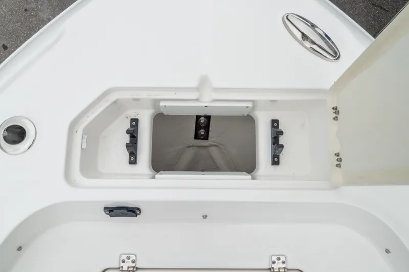 Slide: The Image of 2026 Crevalle 24 HCO boat storage compartment with open hatch and secure latches. - 37