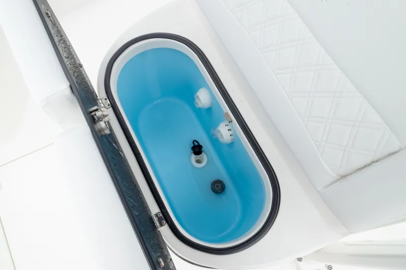 Slide: The Image of Livewell compartment on 2026 Crevalle 24 HCO boat, featuring blue interior and white seating. - 43