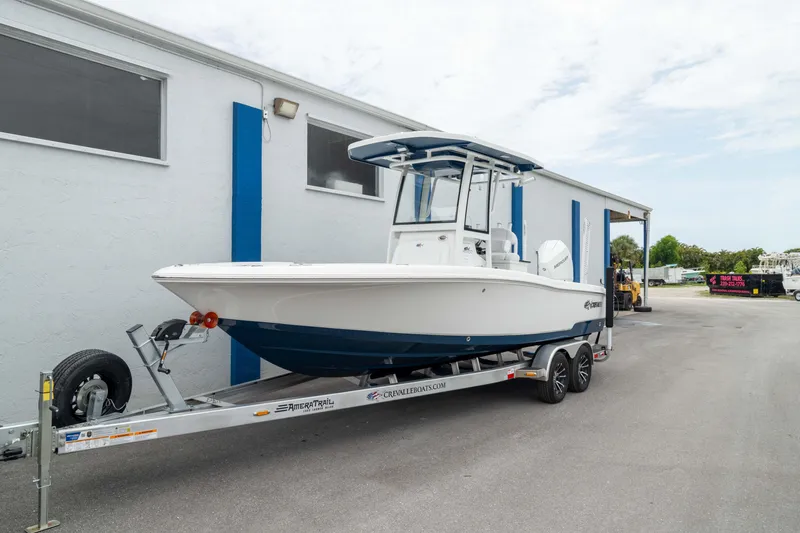 Slide: The Image of 2026 Crevalle 24 HCO boat on trailer, parked beside a building. - 48