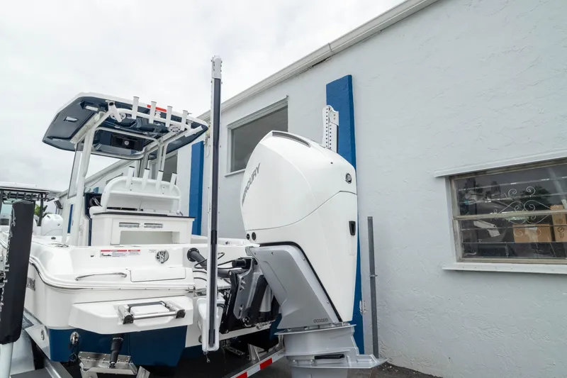 Slide: The Image of 2026 Crevalle 24 HCO boat with powerful outboard motor, parked near a building. - 9