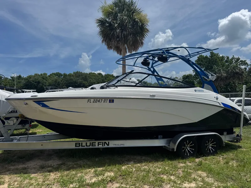 The Image of 2018 Yamaha Boats 242X E-Series on trailer, parked outdoors under a clear sky. - 1