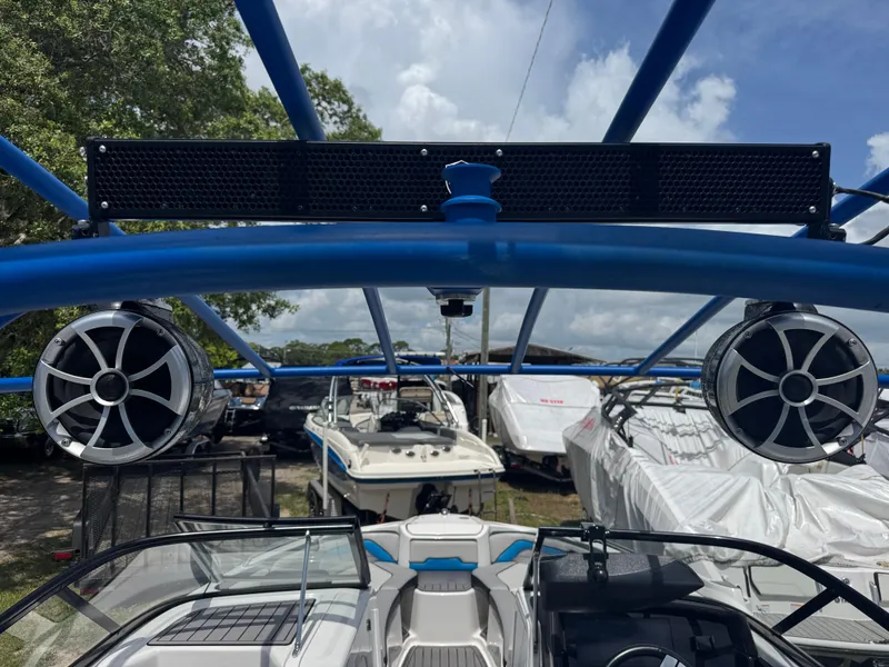 Slide: The Image of 2018 Yamaha Boats 242X E-Series with blue frame and speakers, docked under cloudy sky. - 10