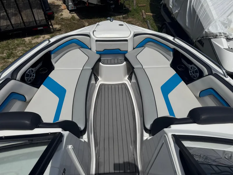 Slide: The Image of 2018 Yamaha Boats 242X E-Series interior with gray and blue seating, sleek design. - 12