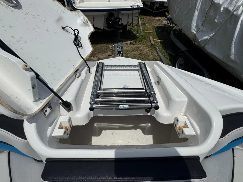 Slide: The Image of 2018 Yamaha Boats 242X E-Series with open storage compartment and ladder. - 17