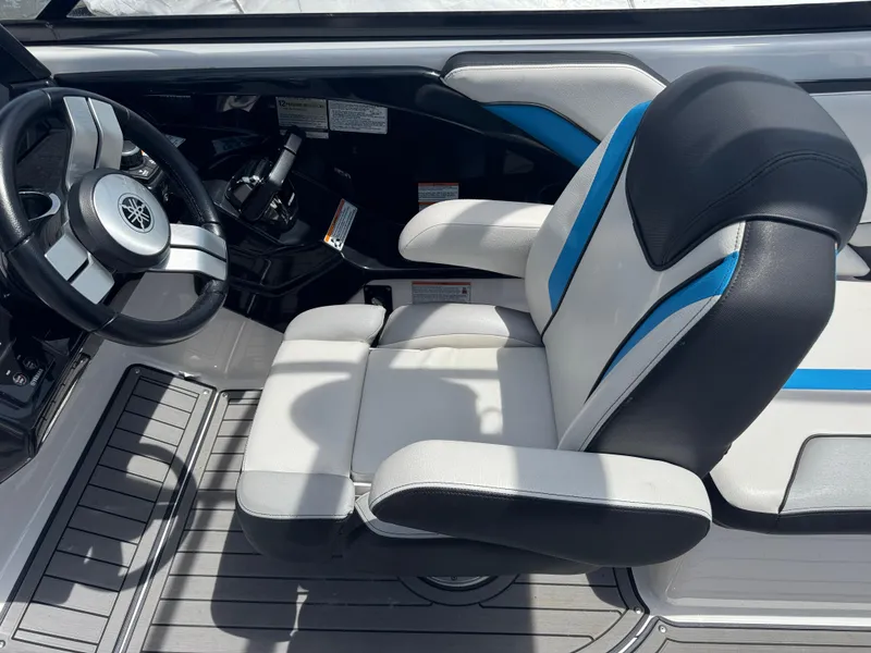 Slide: The Image of 2018 Yamaha Boats 242X E-Series cockpit with steering wheel and cushioned seat. - 22