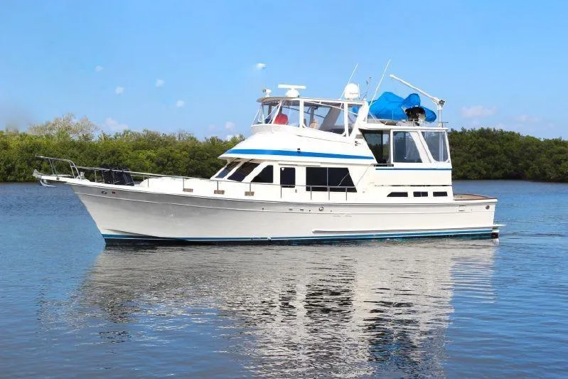 Slide: The Image of 1988 Offshore Yachts 48 CPMY cruising on calm waters under a clear blue sky. - 0