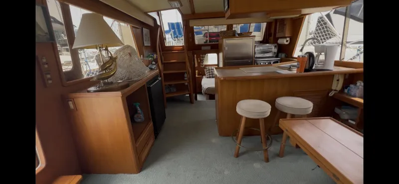 Slide: The Image of Interior of 1988 Offshore Yachts 48 CPMY, featuring cozy seating and wooden cabinetry. - 1