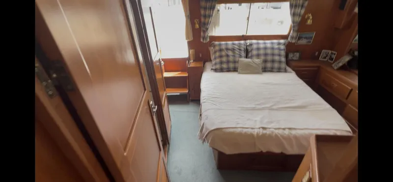 Slide: The Image of Cozy bedroom in 1988 Offshore Yachts 48 CPMY with plaid pillows and wooden interior. - 12