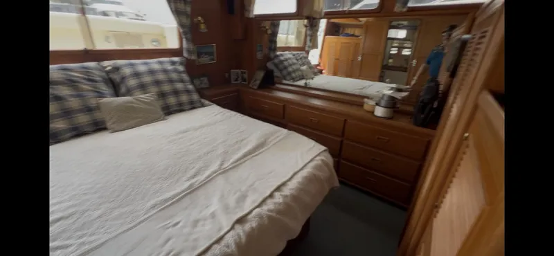 Slide: The Image of Cozy bedroom interior of 1988 Offshore Yachts 48 CPMY with wooden furnishings and plaid bedding. - 13