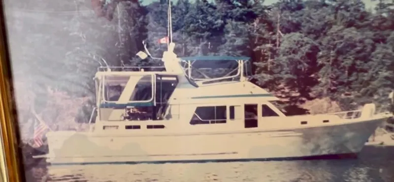 Slide: The Image of 1988 Offshore Yachts 48 CPMY cruising on a serene waterway, surrounded by lush greenery. - 15