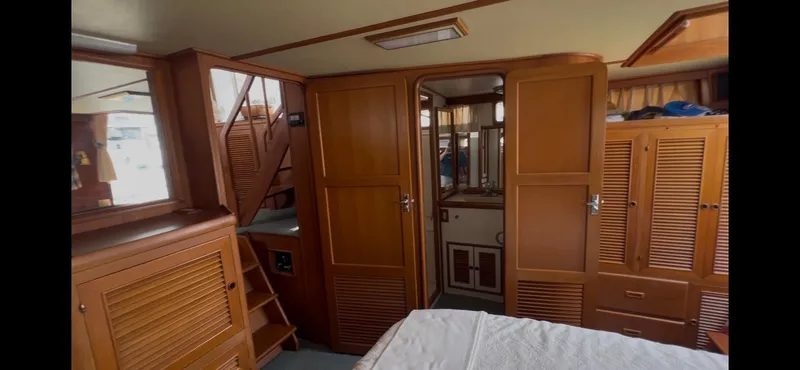 Slide: The Image of 1988 Offshore Yachts 48 CPMY interior with wooden cabinetry and stairs. - 17
