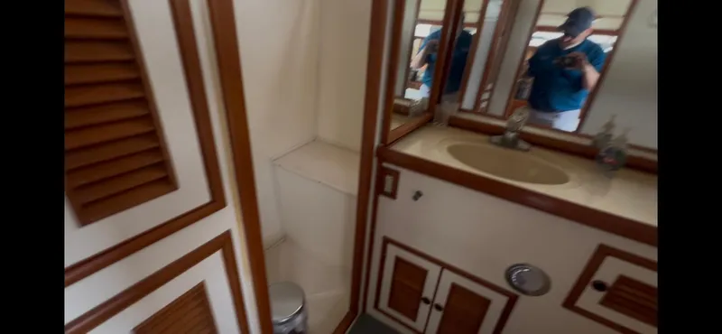 Slide: The Image of 1988 Offshore Yachts 48 CPMY bathroom with wooden accents and mirror. - 18