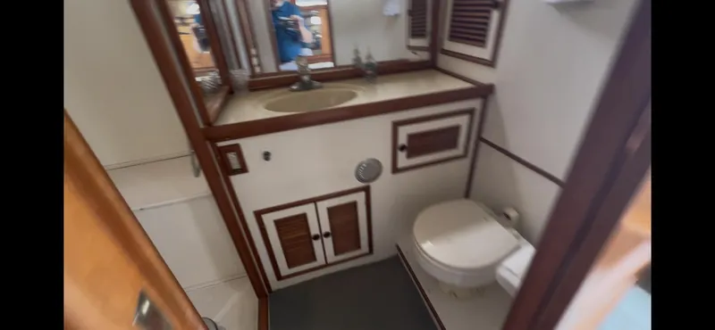 Slide: The Image of 1988 Offshore Yachts 48 CPMY bathroom with sink, toilet, and wooden cabinetry. - 19